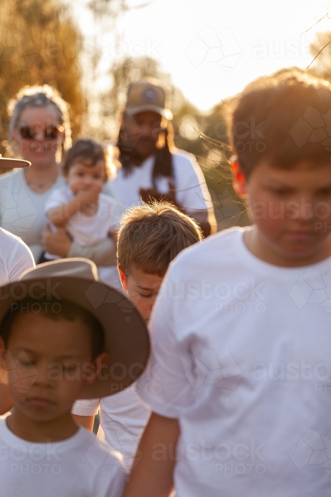 Aboriginal family walking together through bushland - Australian Stock Image