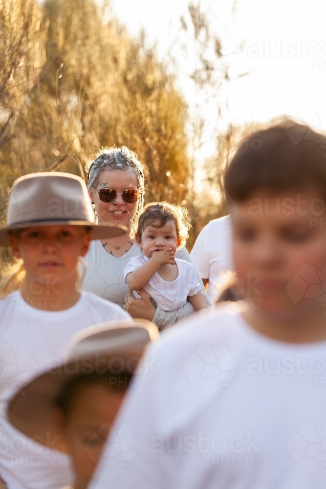 Aboriginal family walking together through bushland - Australian Stock Image