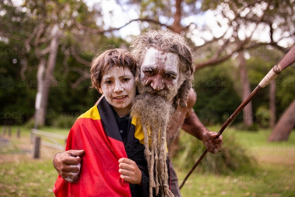 Aboriginal father and son hugging and smiling at the camera - Australian Stock Image