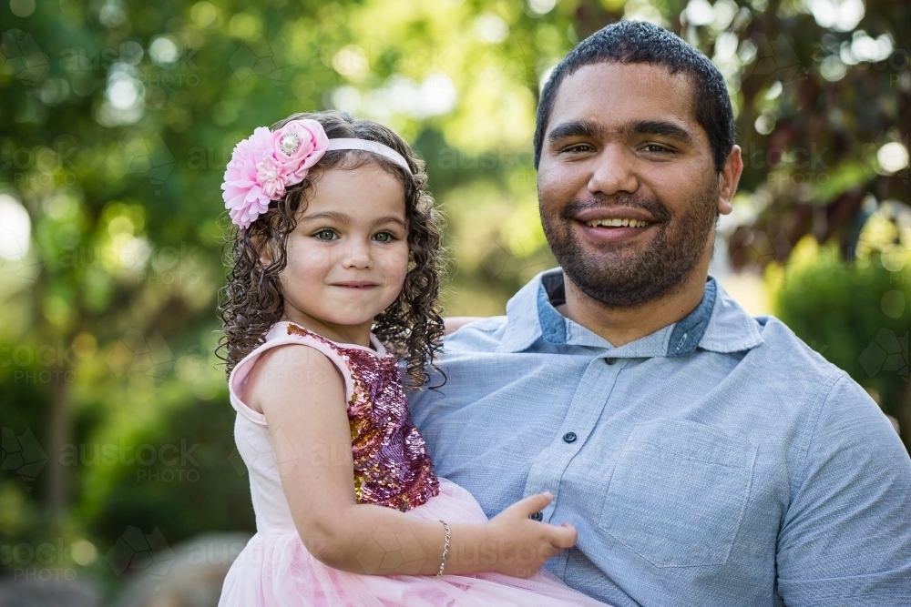 Aboriginal father holding daughter smiling - Australian Stock Image