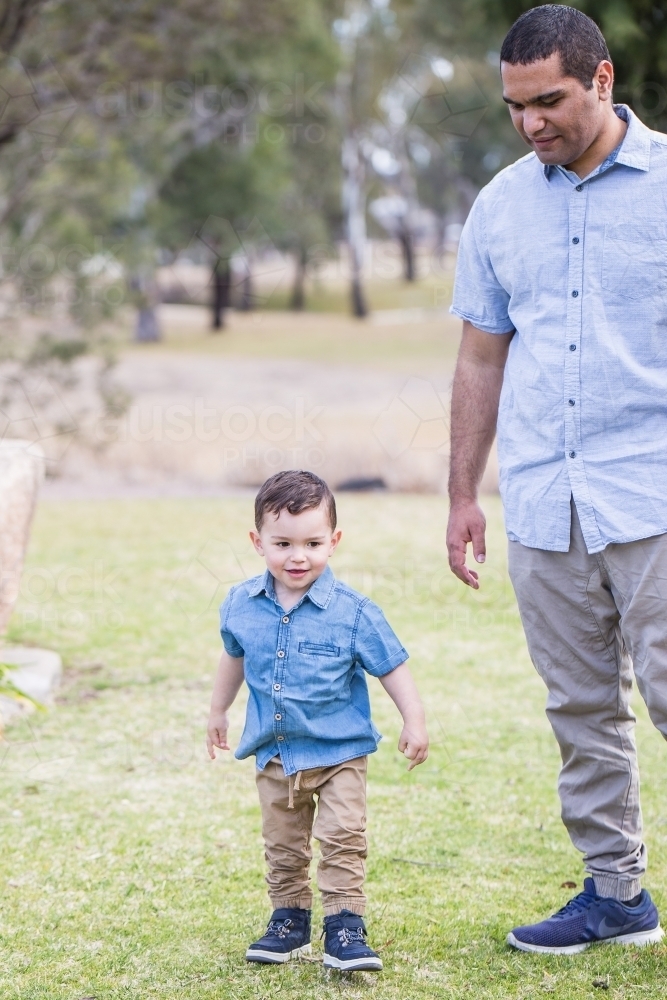 Aboriginal father watching over young mixed race aboriginal caucasian son - Australian Stock Image