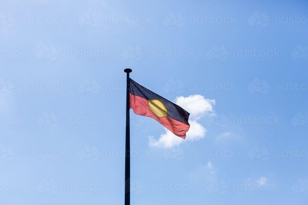 Aboriginal flag flying against a blue sky on a sunny day - Australian Stock Image