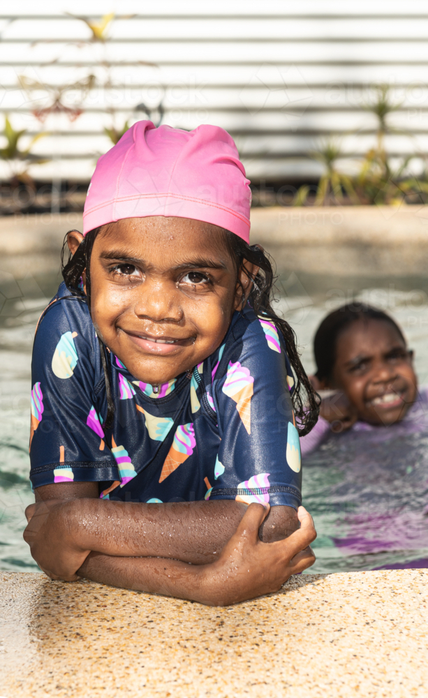 Aboriginal kid leaning on edge of pool - Australian Stock Image