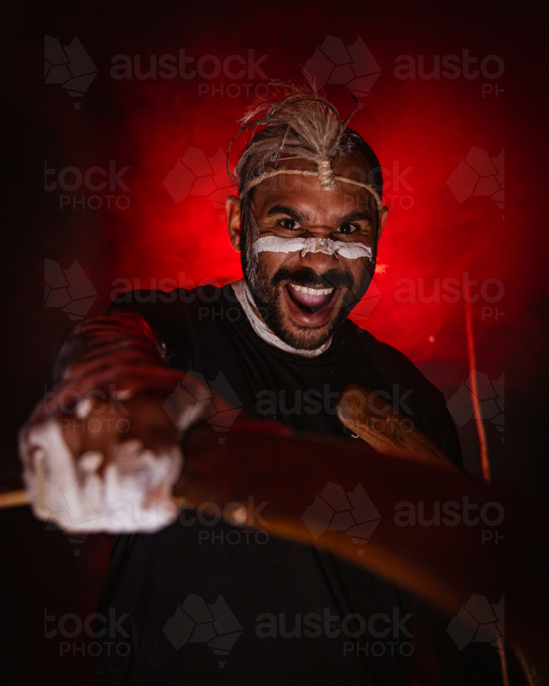 Aboriginal male holding boomerang yelling creative studio portrait - Australian Stock Image