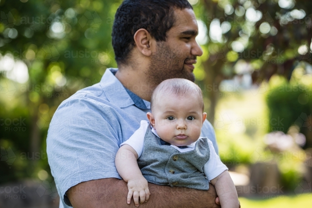 Aboriginal man holding baby - Australian Stock Image