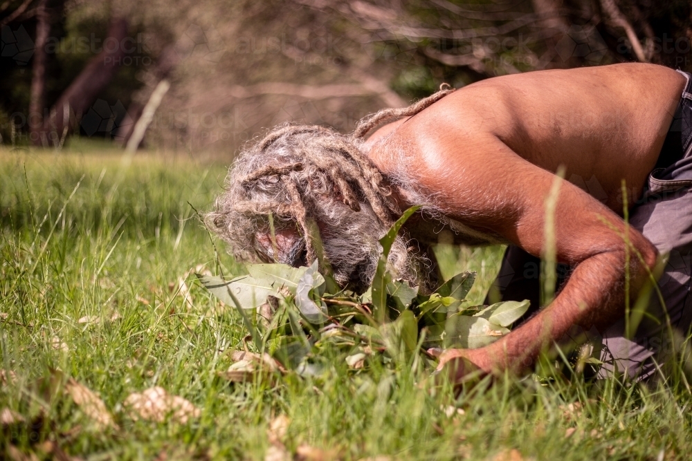 Aboriginal man starting a smoking ceremony - Australian Stock Image