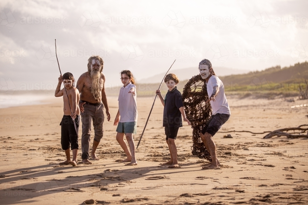 Aboriginal mob at the beach looking at camera elders with school children - Australian Stock Image