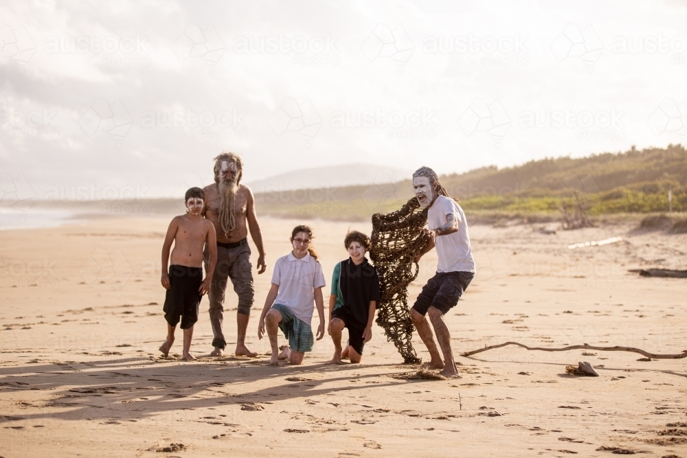 Aboriginal mob at the beach looking at camera focus on foreground - Australian Stock Image