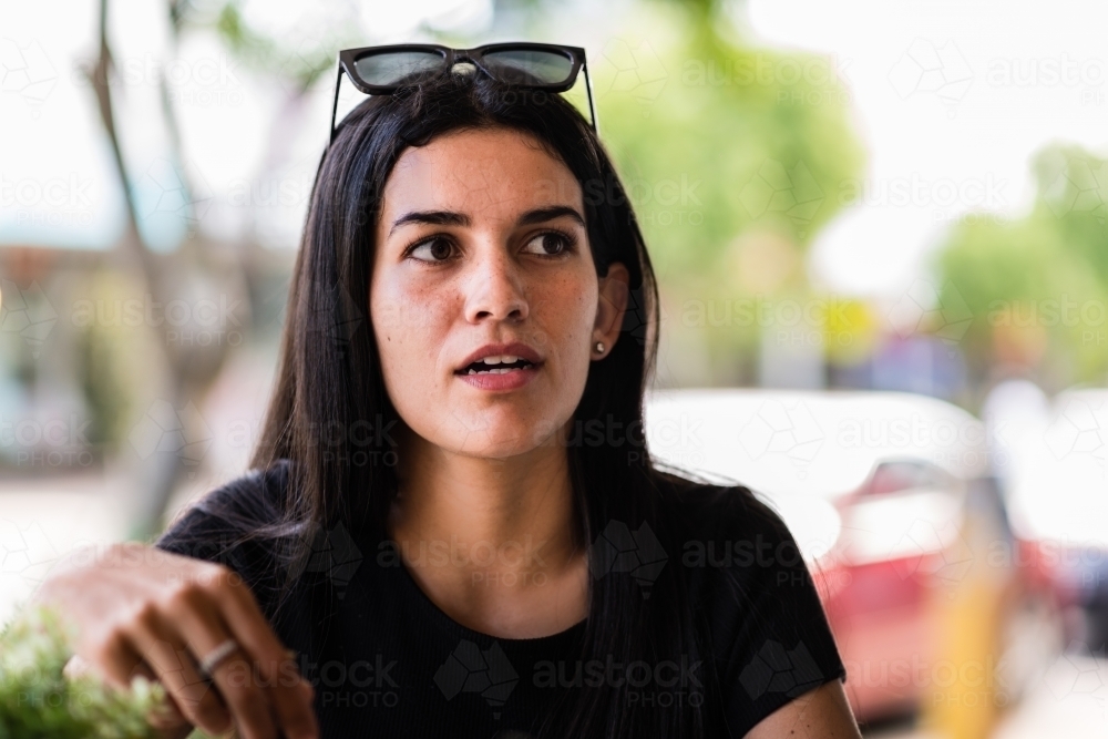 aboriginal woman chatting with friend in a cafe - Australian Stock Image