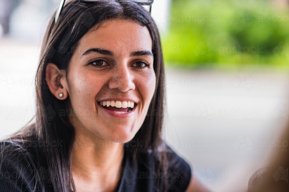 aboriginal woman chatting with friend in a cafe - Australian Stock Image