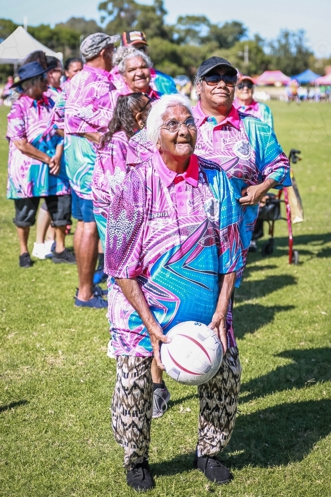 Aboriginal woman crouching to throw netball - Australian Stock Image