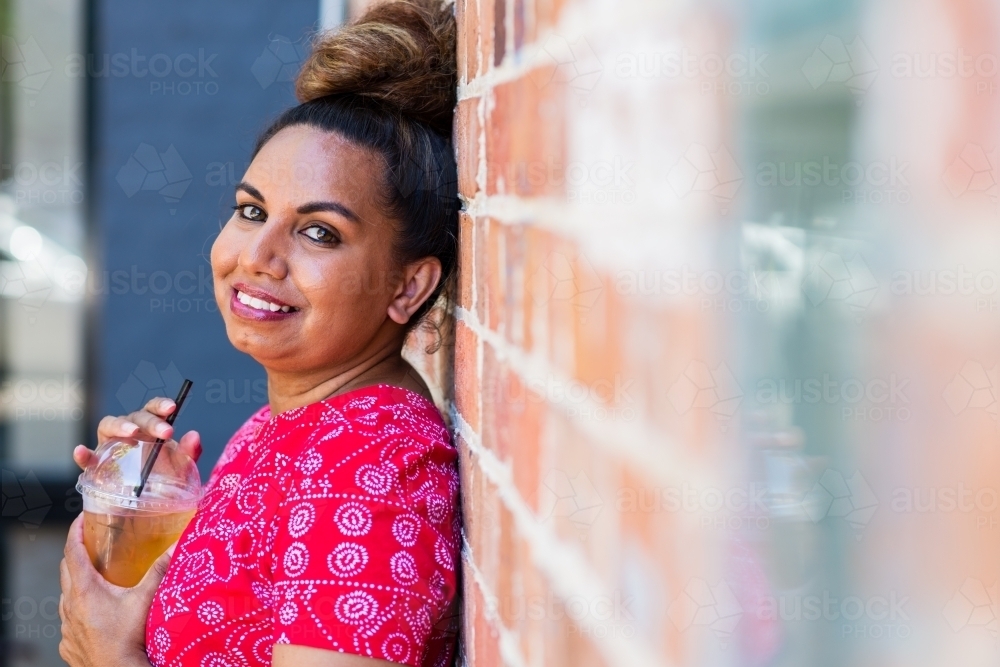 aboriginal woman drinking juice - Australian Stock Image