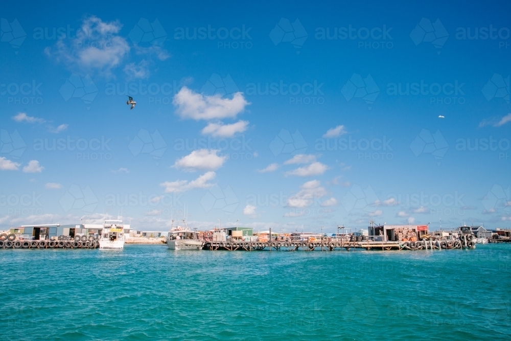 Abrolhos Island crayfishing scene with fishing shacks, jetties, and crayboats - Australian Stock Image