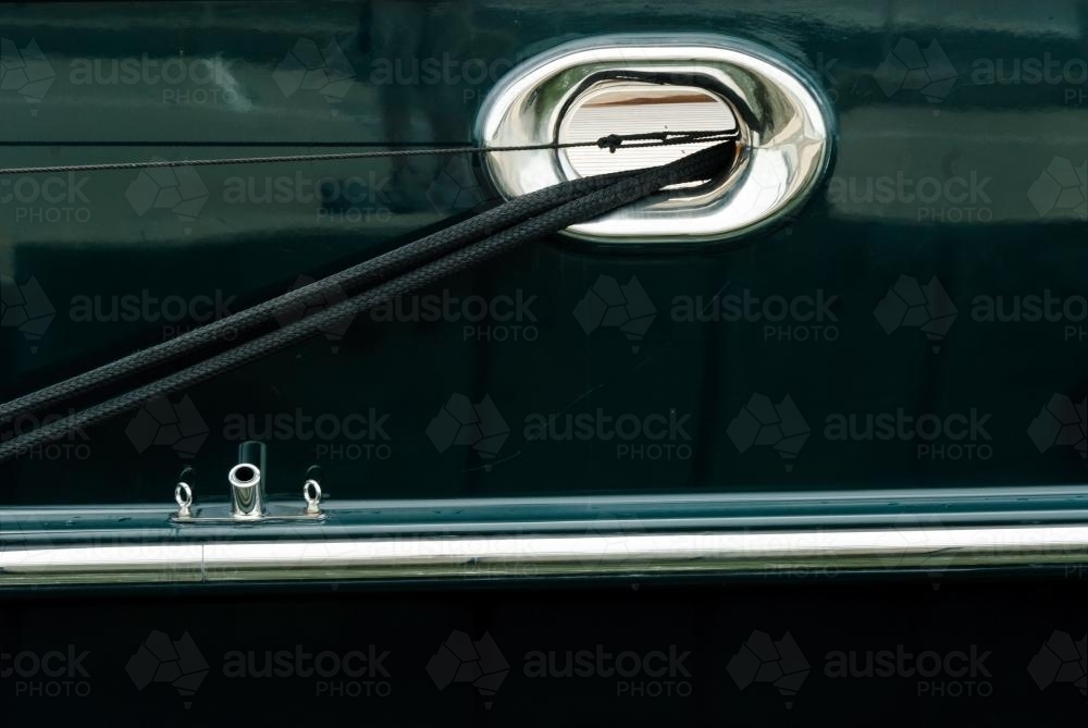 Abstract - Close up of side of yacht with mooring rope and metal parts. - Australian Stock Image