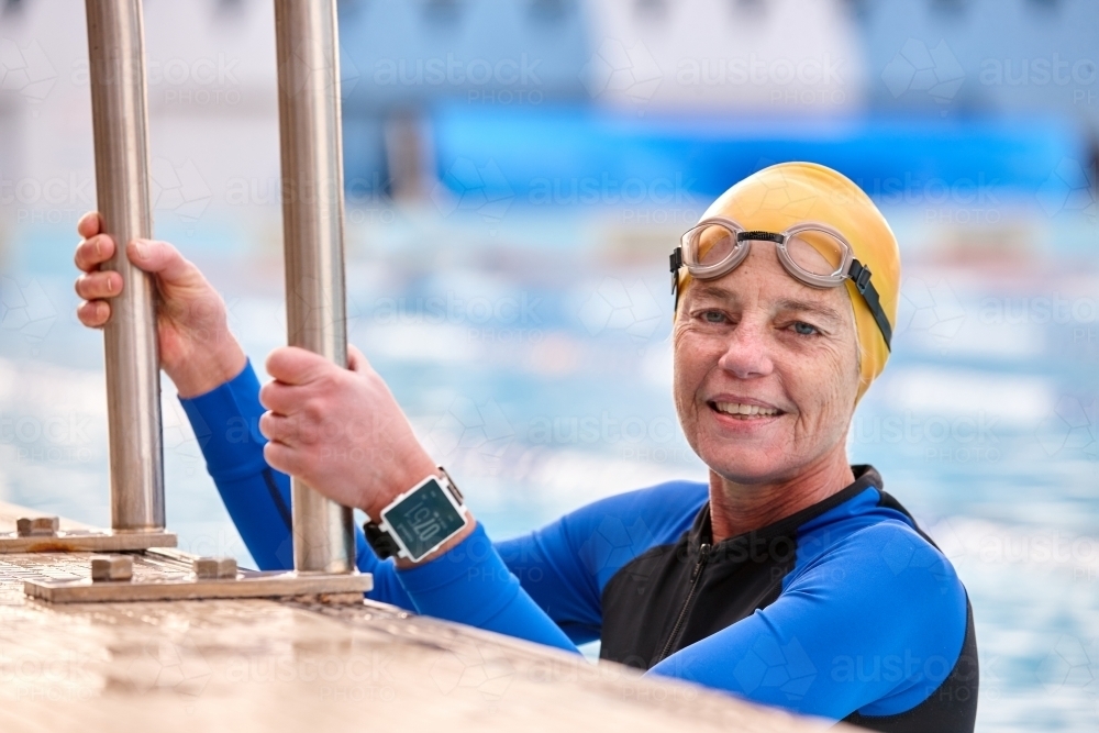 Active senior lady exercising in swimming pool - Australian Stock Image