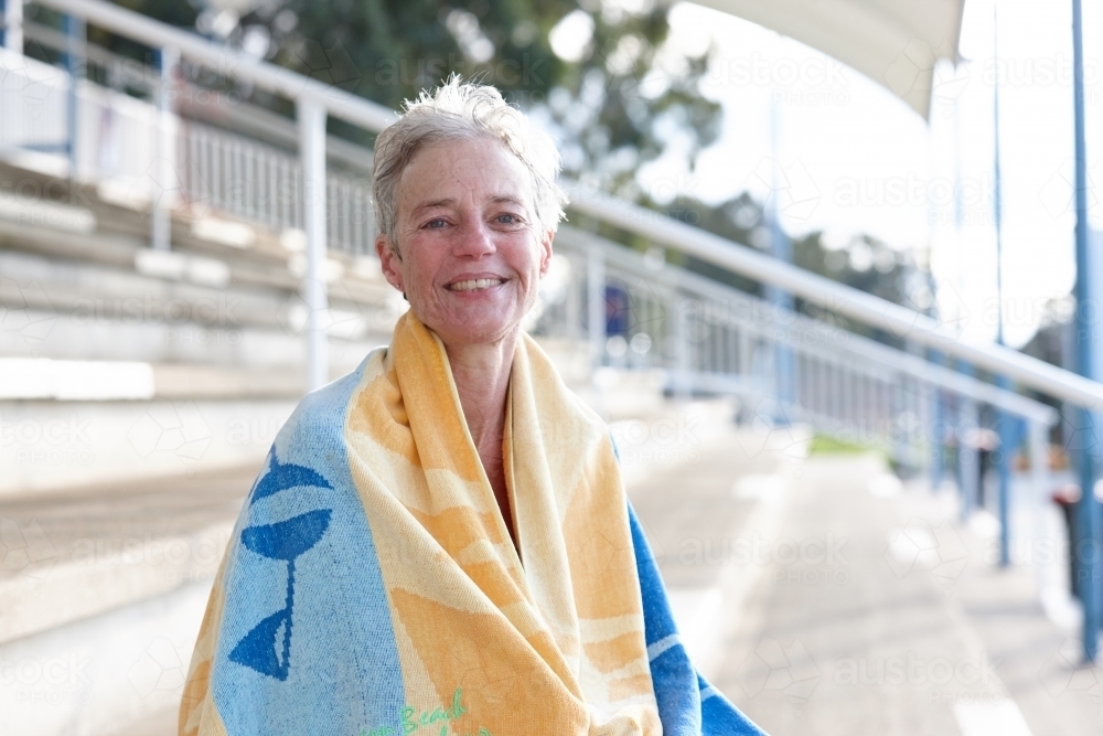 Active senior lady with towel at swimming pool - Australian Stock Image