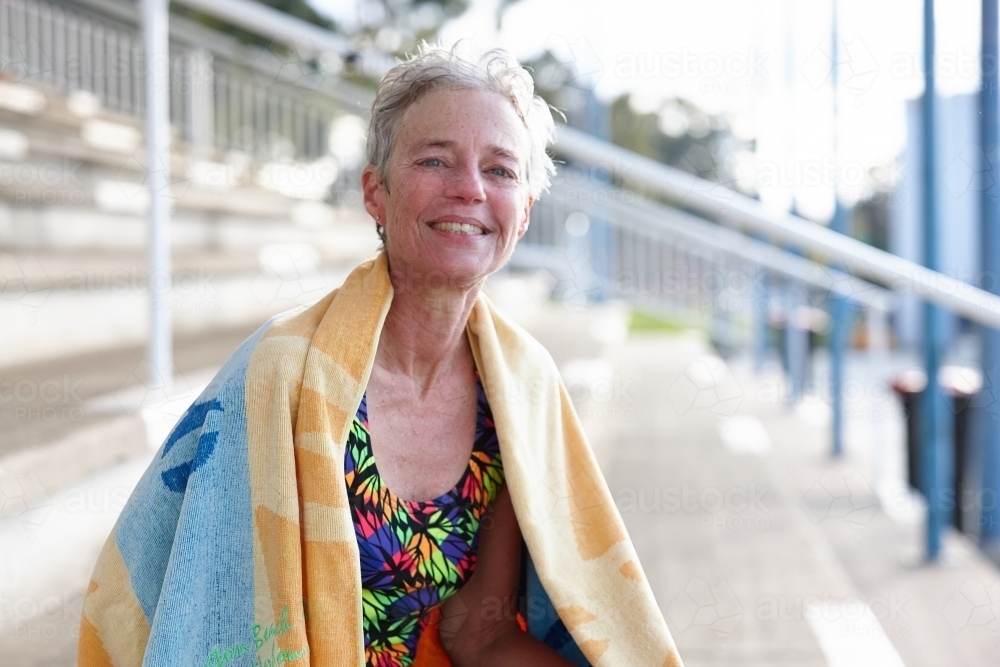 Active senior lady with towel at swimming pool - Australian Stock Image