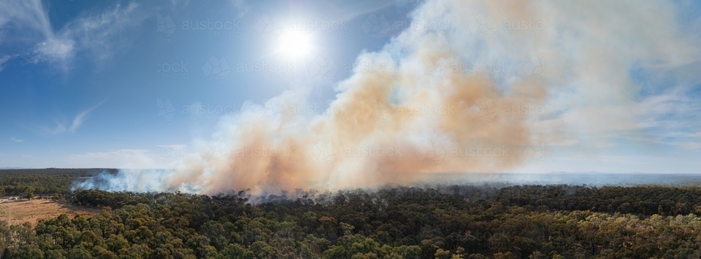 Aerial panorama of plumes of brown bushfire smoke rising from bushland - Australian Stock Image