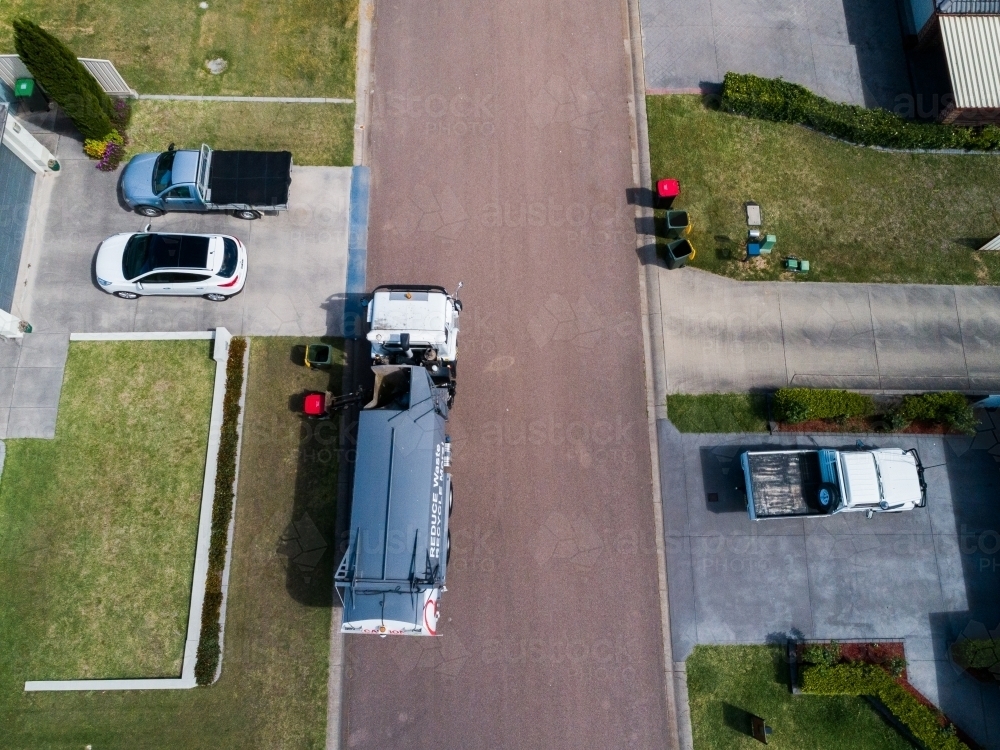 Aerial photo of a garbage truck emptying waste bins along suburban street - Australian Stock Image