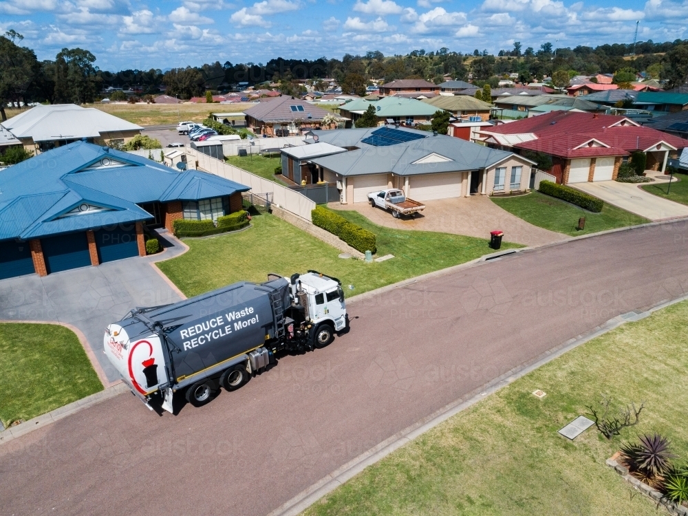 Aerial photo of a garbage truck emptying waste bins along suburban street - Australian Stock Image