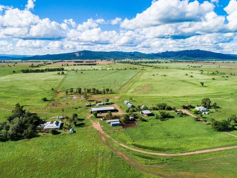 Aerial scene of farm sheds and house among green paddocks - Australian Stock Image