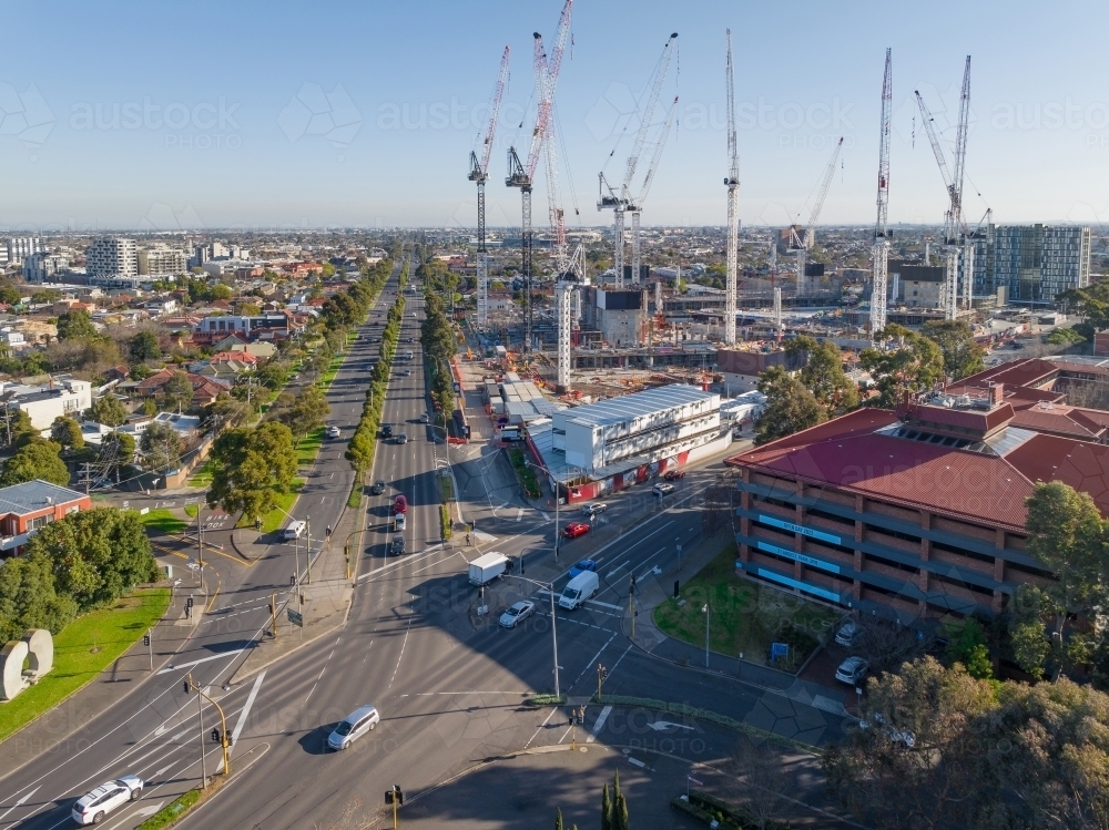 Aerial view a construction site with large cranes alongside city intersection in Footscray - Australian Stock Image