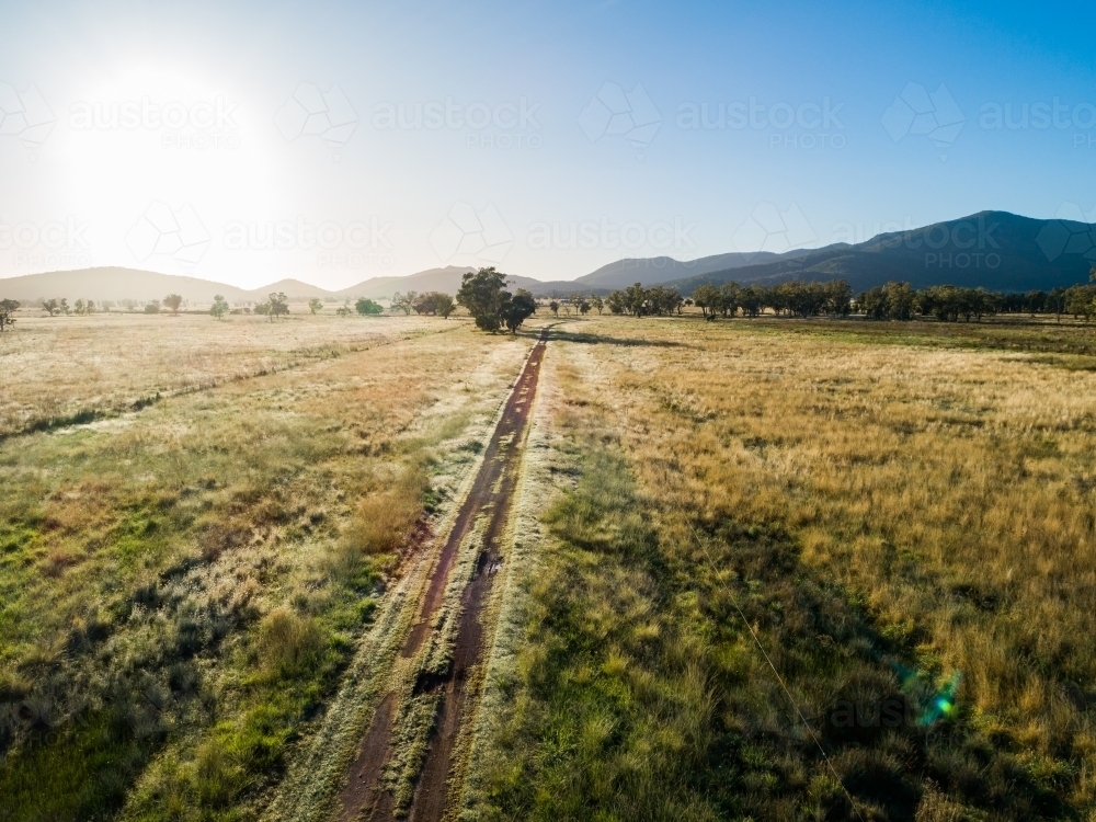 Aerial view down farm driveway at sunrise - Australian Stock Image