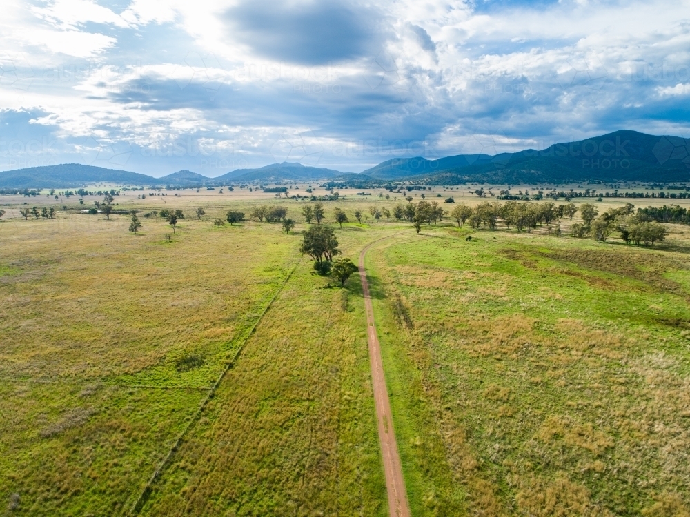 Aerial view down long farm driveway in good season with green paddocks - Australian Stock Image