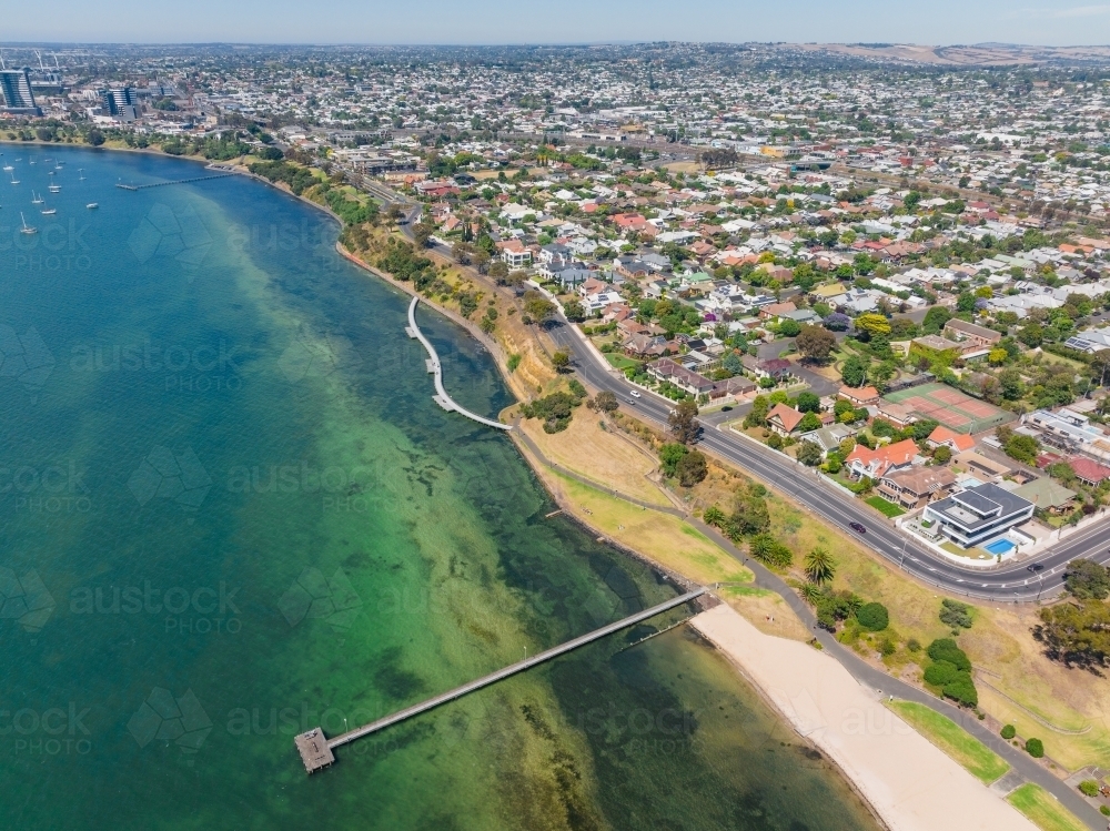 Aerial view of a bay side city waterfront with a long narrow jetty - Australian Stock Image