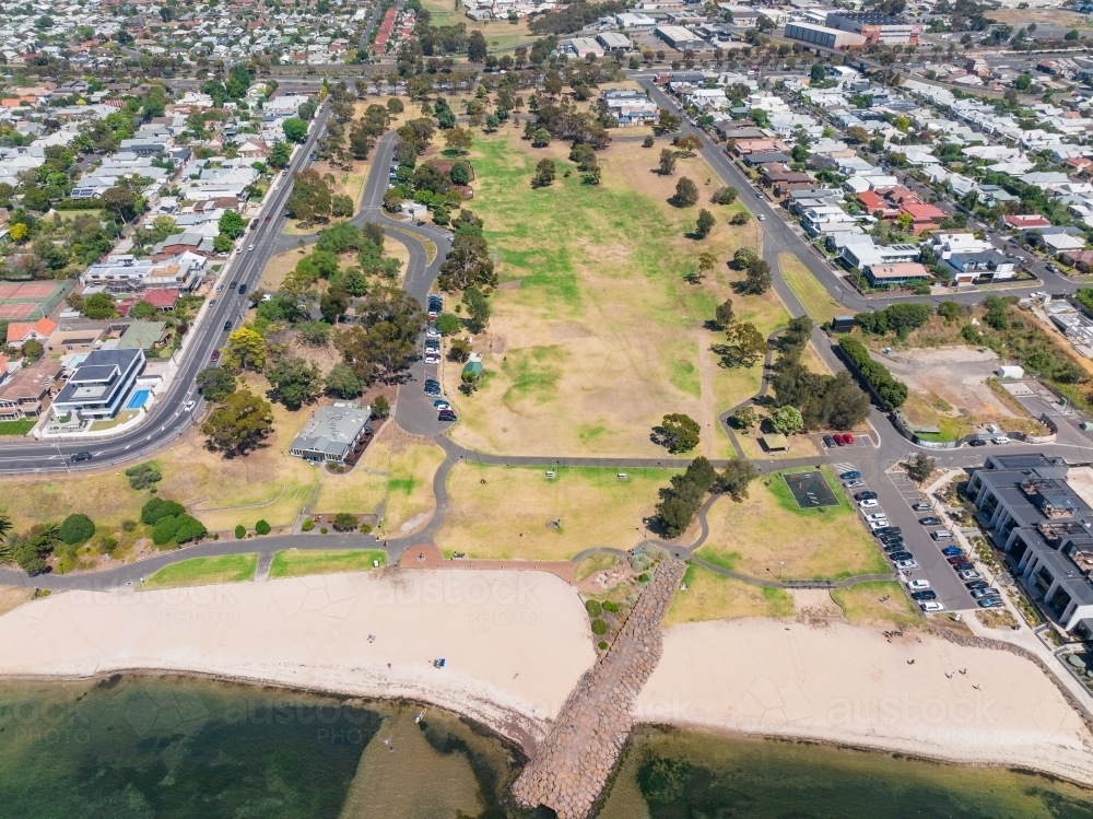 Aerial view of a beach and parkland between bay side residential suburb - Australian Stock Image