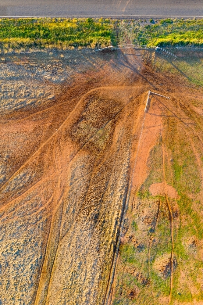 Aerial view of a cattle tracks around a fence line and gate on farmland - Australian Stock Image