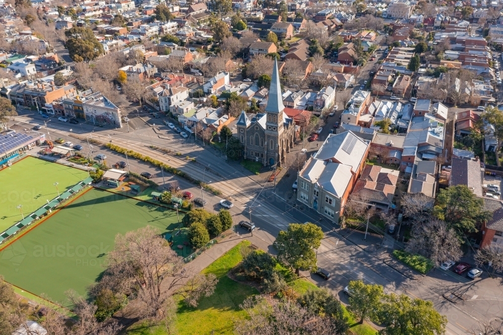 Aerial view of a church and historic buildings across the road from a bowling green in parkland - Australian Stock Image