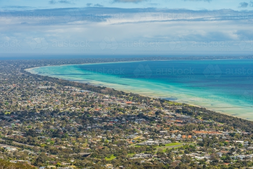 Aerial view of a cloud bank over a bay lined with coastal towns - Australian Stock Image