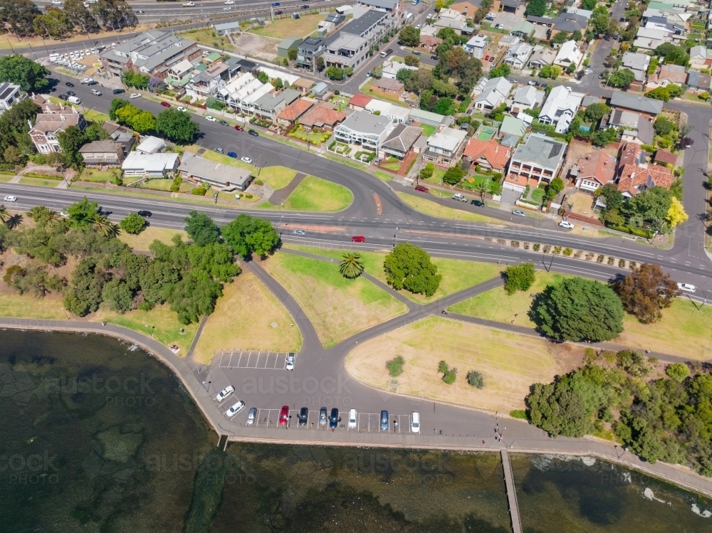 Aerial view of a coastal carpark below a major road and waterfront real estate - Australian Stock Image