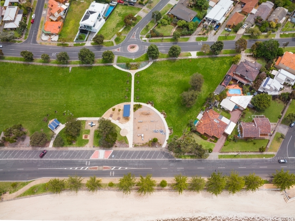 Aerial view of a coastal park between housing and a coastal esplanade - Australian Stock Image