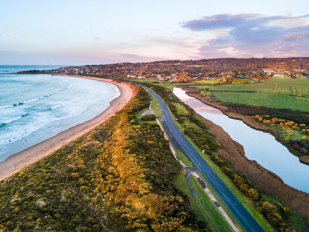 Aerial view of a coastal road with a beach on one side and a river on the other - Australian Stock Image