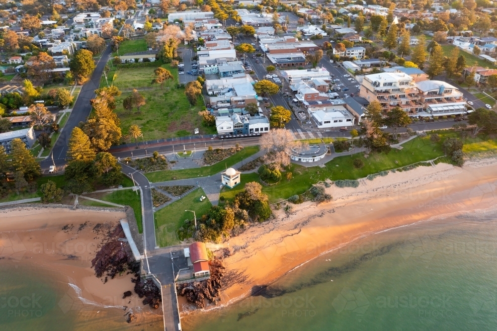 Aerial view of a coastal town behind a sandy beach and a foreshore reserve - Australian Stock Image