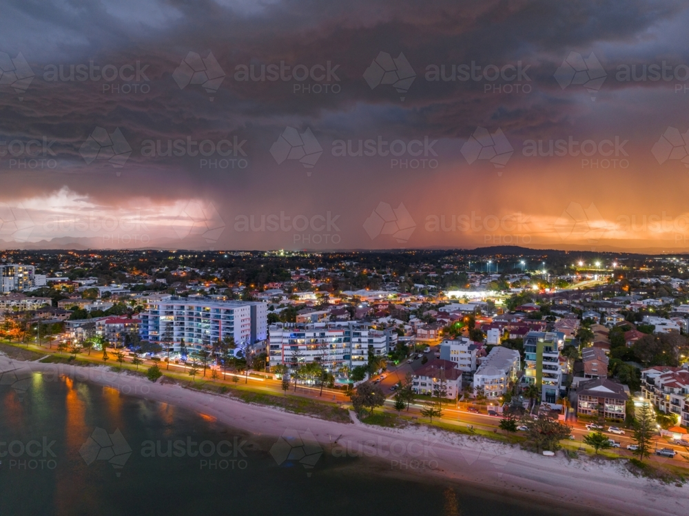 Aerial view of a dramatic thunderstorm advancing over apartment buildings along a coastal esplanade - Australian Stock Image