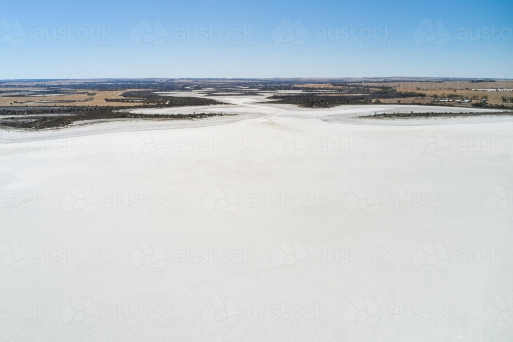 Aerial view of a dry salt lake in Western Australia under clear blue skies. - Australian Stock Image