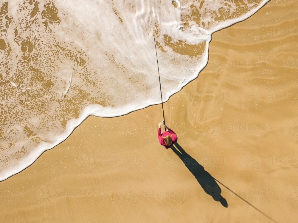 Aerial view of a fisherman and waves on a beach - Australian Stock Image