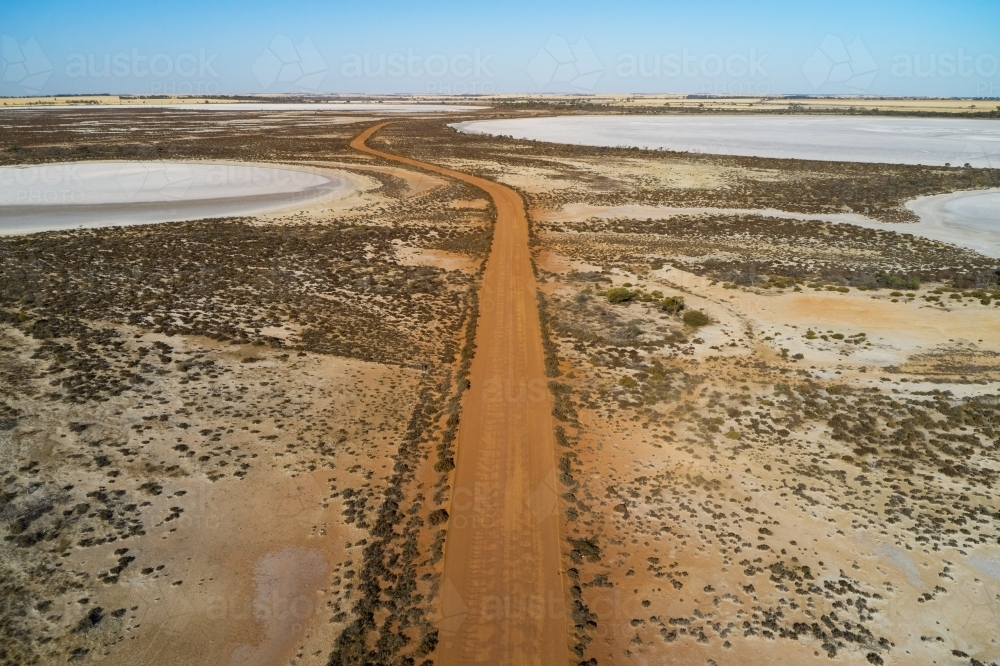 Aerial view of a gravel road going through small dry salt lakes in the Australian summer. - Australian Stock Image