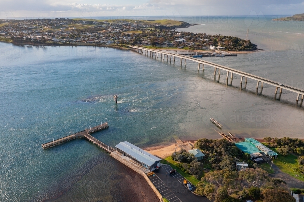 Aerial view of a jetty and narrow bridge linking the mainland to a coastal island - Australian Stock Image