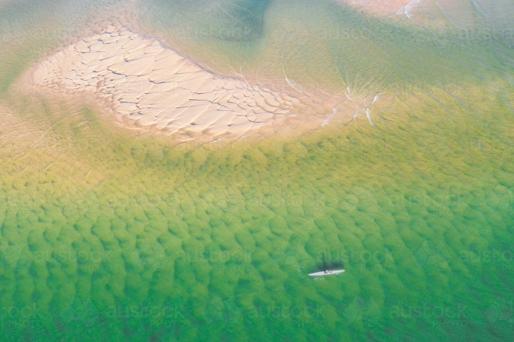 Aerial view of a kayak amongst tidal sandbars and blue green  water - Australian Stock Image