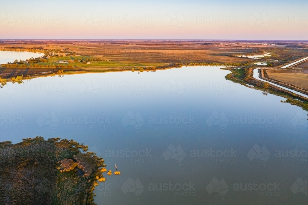 Aerial view of a large calm inland lake at sunset - Australian Stock Image