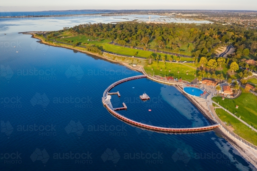Aerial view of a large circular swimming enclosure along a coastal waterfront - Australian Stock Image