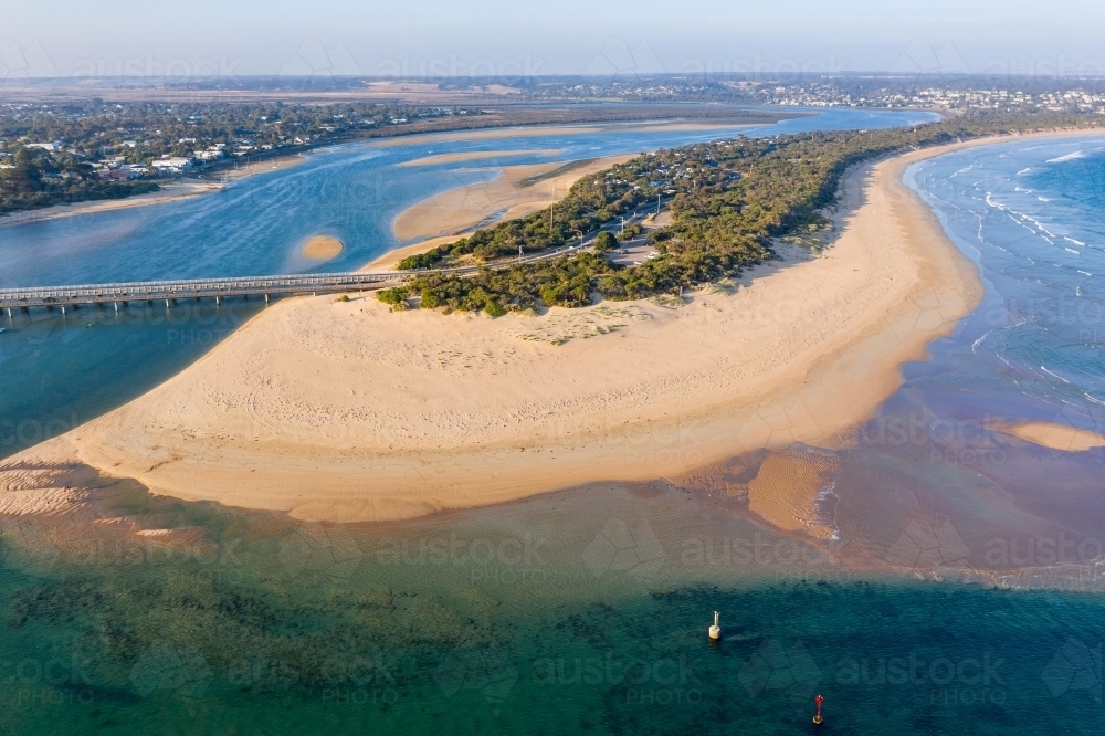 Aerial view of a large sand spit and bridge crossing a tidal river - Australian Stock Image