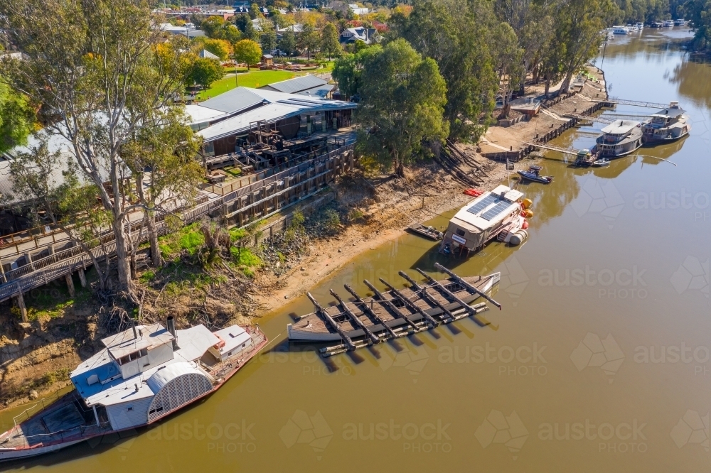 Aerial view of a line of paddle steamers anchored along a river bank - Australian Stock Image