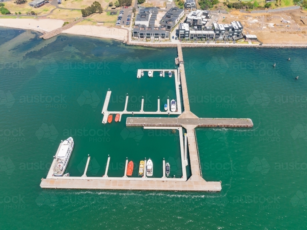 Aerial view of a marina next to a building development on a waterfront - Australian Stock Image