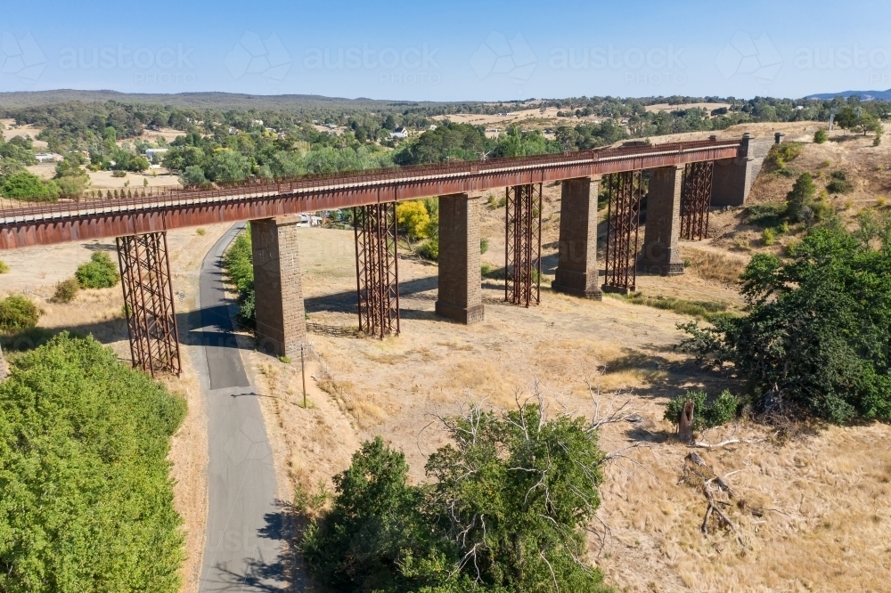 Aerial view of a railway viaduct over a country road - Australian Stock Image