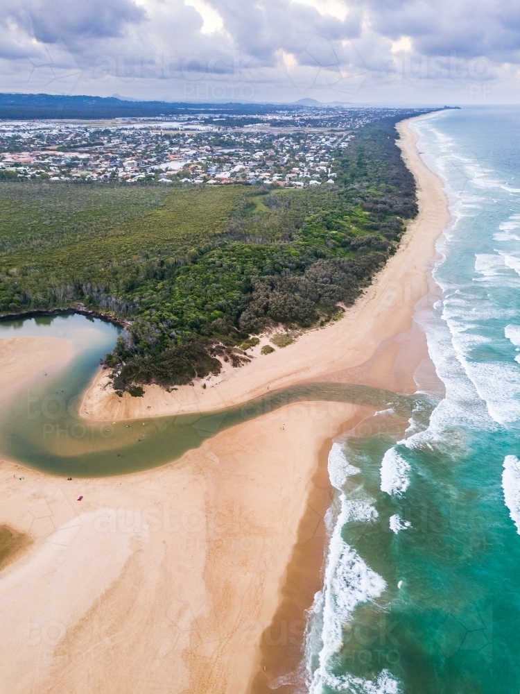 Aerial view of a river winding through a beach and out to sea - Australian Stock Image